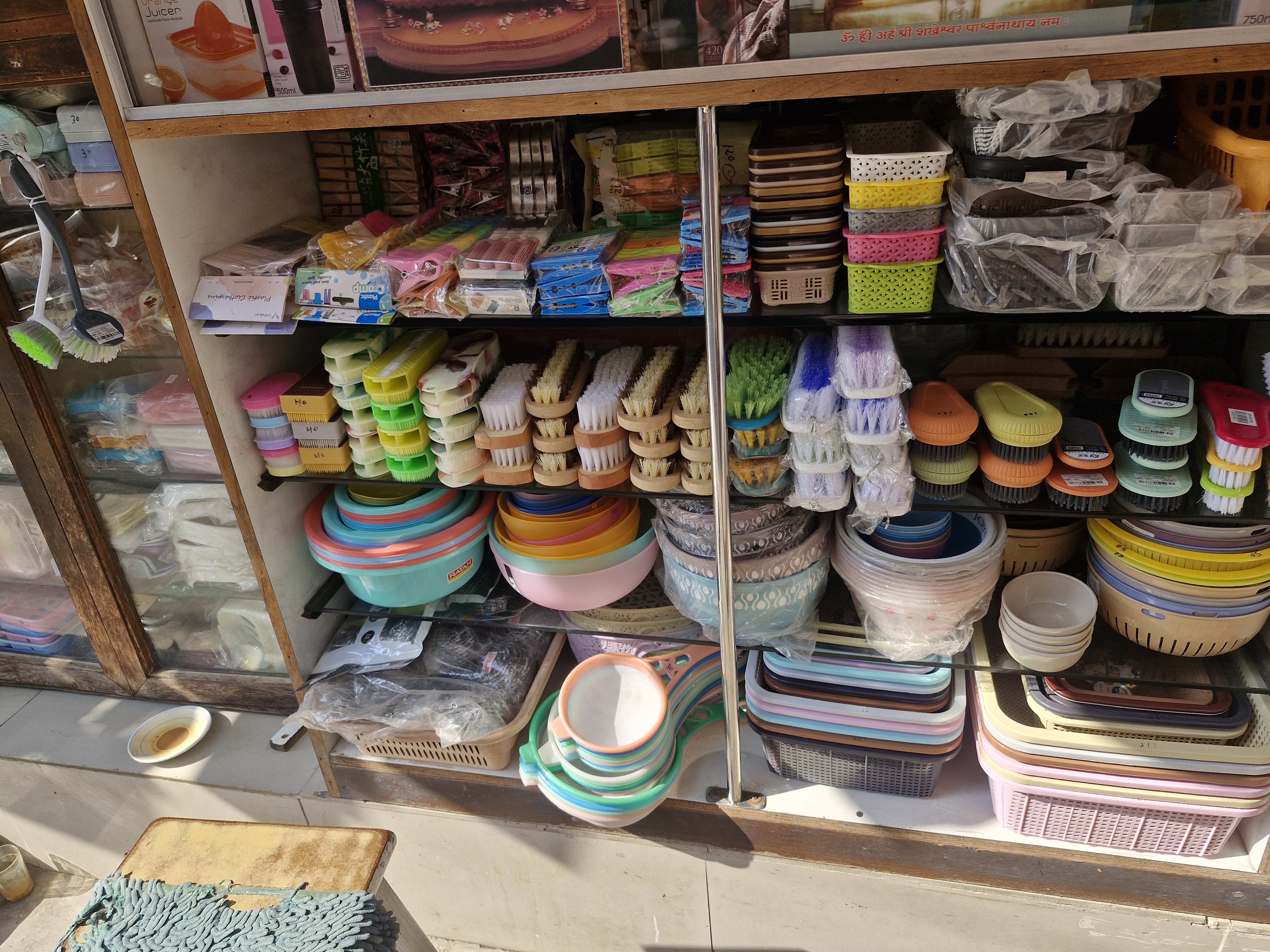 Detailed shelf display of colorful plastic bowls, baskets, and cleaning supplies